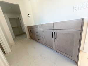 Bathroom featuring vanity and light marble finish flooring