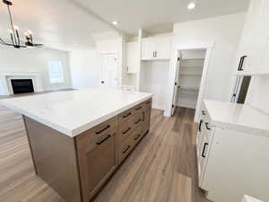 Kitchen featuring an expansive island with a light-colored countertop and two-tone cabinetry