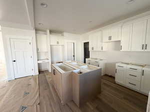 Kitchen featuring a center island, white cabinets, dark wood-type flooring, and recessed lighting