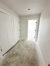 Corridor with unfinished concrete floors and baseboards