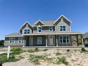 View of front of house featuring covered porch and roof with shingles