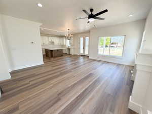 Open-concept living space featuring wood-finish flooring, recessed lighting, and a contemporary ceiling fan