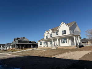 Modern inspired farmhouse featuring covered porch, board and batten siding, a residential view, and roof with shingles