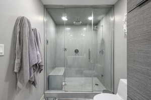 Bathroom featuring toilet and a stall shower