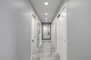 Hall with baseboards and recessed lighting