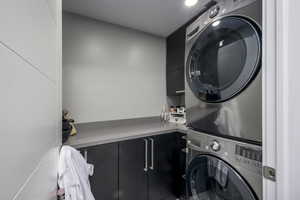 Laundry room featuring estacked washer and dryer and cabinet space