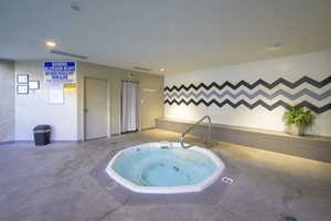 View of pool with a hot tub