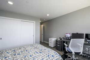 Bedroom with a closet, recessed lighting, and dark carpet