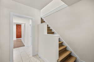 Stairs featuring baseboards and marble finish floors