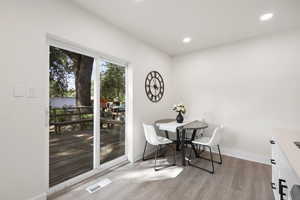 Dining area with light wood-style floors and recessed lighting