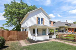 American foursquare style home with a porch and roof with shingles