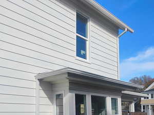 View of side of home featuring a wooden deck