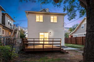Back of property with a deck with mountain view and a fenced backyard