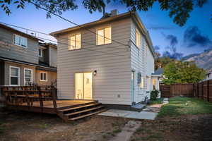 Back of house with a chimney and a deck with mountain view