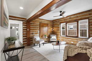 Sitting room with ceiling fan and wood finished floors