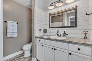 Full bath featuring vanity and wood finished floors