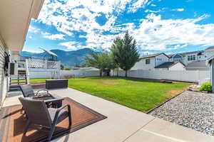 Fenced backyard with an outdoor fire pit, a mountain view, and a patio area
