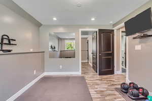 Workout area with wood finished floors and recessed lighting