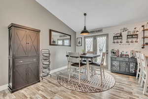 Dining space with light wood finished floors and lofted ceiling