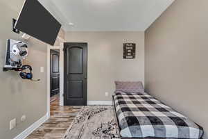 Bedroom with wood finished floors and baseboards