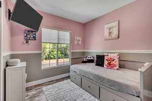 Bedroom featuring wood finished floors and baseboards