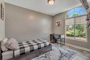 Bedroom featuring wood finished floors and baseboards