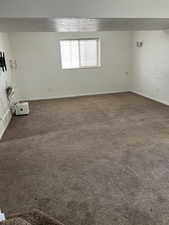 Spare room with dark carpet and baseboards