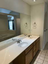 Full bathroom featuring light tile patterned floors, double vanity, a bath, and recessed lighting