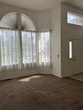 Foyer with carpet and a high ceiling