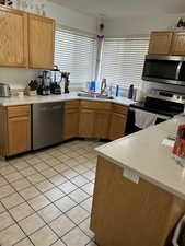 Kitchen featuring appliances with stainless steel finishes, light tile patterned floors, and light countertops