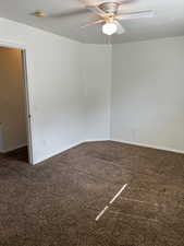 Unfurnished room with dark colored carpet, a textured ceiling, ceiling fan, and a smoke detector