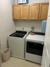 Laundry room featuring separate washer and dryer and cabinet space