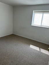 Unfurnished room featuring carpet floors and baseboards