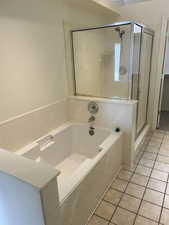 Full bath with a shower stall, a bath, light tile patterned floors, and a closet