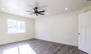 Empty room with dark wood-style flooring, ceiling fan, and recessed lighting