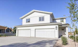 View of front of house featuring an attached garage, board and batten siding, and concrete driveway