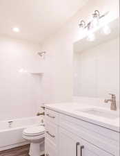 Bathroom with vanity,  shower combination, and wood finished floors