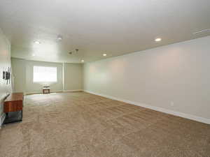 Carpeted spare room with a textured ceiling and recessed lighting