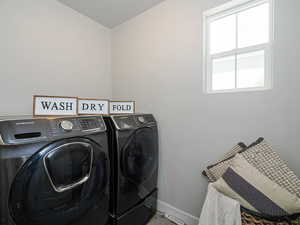Laundry room featuring baseboards and washing machine and dryer