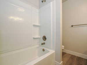 Full bath featuring wood finished floors and shower / bath combination