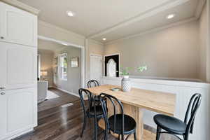 Dining area featuring crown molding, dark wood-style flooring, and recessed lighting
