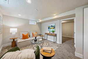 Carpeted living room featuring a textured ceiling and recessed lighting