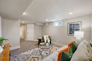 Carpeted living room with a textured ceiling and recessed lighting