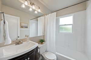 Full bath featuring vanity and shower / bath combination with curtain
