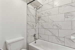 Bathroom featuring toilet and shower / washtub combination