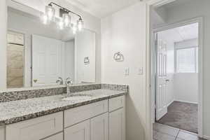 Bathroom featuring vanity, a textured ceiling, and tile patterned flooring
