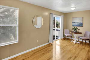 Living area with light wood-type flooring and a textured ceiling