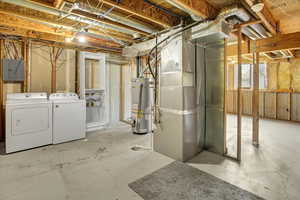Unfinished below grade area with separate washer and dryer, heating unit, water heater, and electric panel