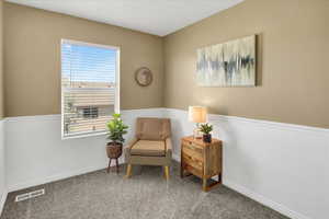 Sitting room with baseboards and carpet flooring