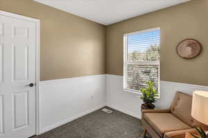 Sitting room with baseboards and dark carpet